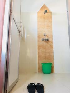 a bathroom with a shower and two shoes on the floor at Hotel Milarepa Pvt Ltd in Pokhara