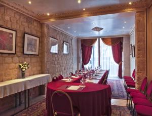 une grande salle à manger avec des tables et des chaises rouges dans l'établissement Hotel Minerve, à Paris