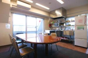 a kitchen with a table and chairs and a refrigerator at Sakura Hotel Ikebukuro in Tokyo