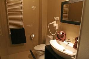 a bathroom with a sink and a toilet and a mirror at Hotel Altamira in Piotrków Trybunalski +19 photos