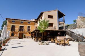 a courtyard with tables and chairs in front of a building at Las Ollerias in Deza