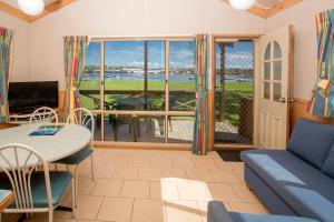 een woonkamer met een bank en een tafel bij BIG4 Batemans Bay at Easts Riverside Holiday Park in Batemans Bay