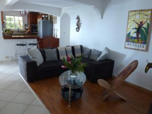 a living room with a couch and a table at Kreyol Lodges - Suite Kayou in Deshaies