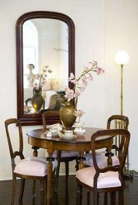 una mesa con un jarrón con sillas y un espejo en Huitfeldsgate en Oslo
