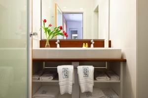 a bathroom with a sink, mirror, and towel rack at Apartamentos Eslava in Seville