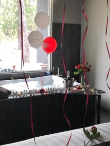 a room with red and white balloons and a tub at Spa Suites at RAVEN in Hepburn Springs