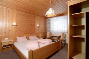 ein Schlafzimmer mit einem Bett in einem Holzzimmer in der Unterkunft Haus Ladner - Josef und Marianne in Kappl