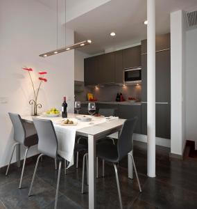 a dining room table and chairs in a room at Apartamentos Eslava in Seville