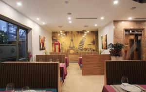 a restaurant with tables and chairs and a painting on the wall at Oriana Hotel in Hanoi