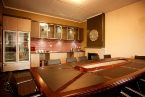a conference room with a table and a kitchen at Prince of Wales Hotel, Bunbury in Bunbury