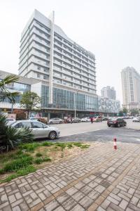 um parque de estacionamento com carros estacionados em frente a um grande edifício em Metropolo, Hefei, Wanda Plaza, Swan Lake em Hefei