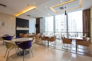 a restaurant with tables and chairs and a large window at Metropolo, Hefei, Wanda Plaza, Swan Lake in Hefei
