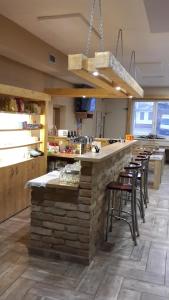 a large kitchen with a bar with stools at Hospůdka U Smrku in Nový Poddvorov