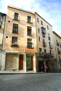 a building on a street with people standing in front of it at Hotel Domus Plaza Zocodover in Toledo