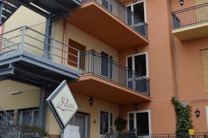 una señal frente a un edificio con balcones en La Lanterna Hotel en Rometta Marea
