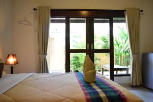 a bedroom with a bed and a sliding glass door at Meisya Cottage in Gili Trawangan