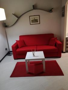 a living room with a red couch and a table at Nonna Anna in Siena