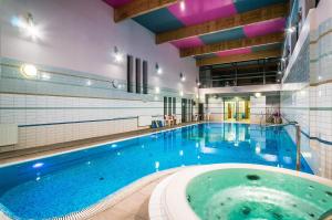 a large indoor swimming pool with a large tub at Hotel ***NAT Świnoujście in Świnoujście