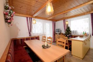 a living room with a wooden table and a kitchen at Haus Ladner - Josef und Marianne in Kappl