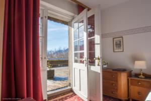 eine offene Tür zu einem Zimmer mit roten Vorhängen in der Unterkunft Hotel Grünwalderhof in Innsbruck