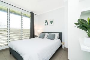 Habitación blanca con cama y ventana en Private Pool, Big Backyard, Aircon - Paradise!, en Casuarina