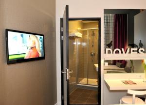 baño con TV en la pared y ducha en ibis Styles Amsterdam Amstel, en Ámsterdam