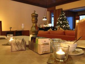 a table with candles and a christmas tree in a living room at Bed&Garden in Cesate