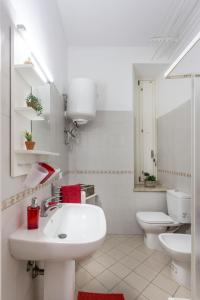 a white bathroom with a sink and a toilet at Sicily Mon Amour Ortigia in Siracusa