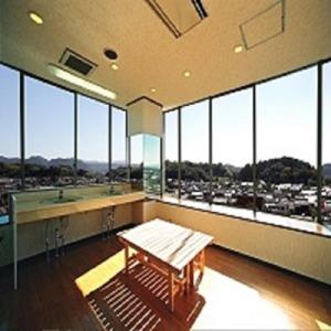 a large room with a bench and large windows at Business Green Hotel Hino in Hino