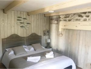 a bedroom with a large bed with towels on it at Chez Les Hollandais in Roscanvel