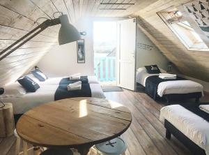 a room with two beds and a table in it at Île ô des capucins in Roscanvel