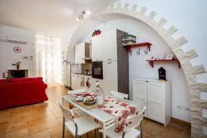 a kitchen and living room with a table and chairs at Sicily Mon Amour Ortigia in Syracuse
