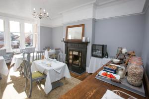 a dining room with a table and a fireplace at Fernleigh in Robin Hood's Bay