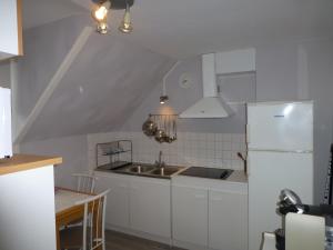 een keuken met een wastafel en een witte koelkast bij Location Ker Bihan in Saint-Lunaire