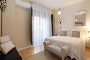 Un dormitorio con una cama, una silla y un espejo. en tuGuest Catedral Apartment, en Granada