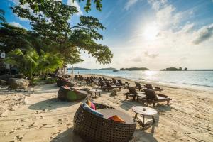 una spiaggia con sedie e tavoli e l'oceano di Muang Samui Spa Resort - SHA Extra Plus a Chaweng Beach