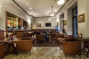 a lobby of a bar with people sitting in chairs at Capitol Hotel in Bucharest