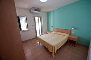Кровать или кровати в номере Villaggio Turistico Le Diomedee