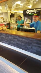 dos hombres parados en el mostrador de un restaurante de comida rápida en Motell Trafikanten en Bygdeå