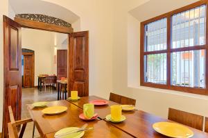 a dining room with a wooden table with yellow dishes on it at Hotel J, Unawatuna in Unawatuna