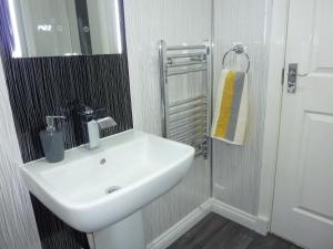 a bathroom with a white sink and a mirror at Paisley Central Apartment #2 in Paisley +17 photos