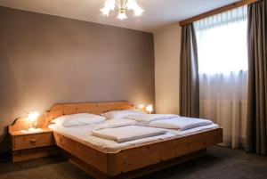 Schlafzimmer mit einem Bett mit weißer Bettwäsche und einem Fenster in der Unterkunft Gästehaus Prock in Mieders