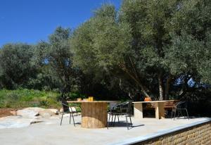 a patio with a table and chairs and trees at Marathon Eco Stay in Marathon