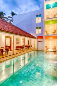 a swimming pool in front of a building at Hotel J, Unawatuna in Unawatuna