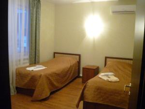 サマラにあるDubrava Park-Hotelのベッド2台と壁の照明が備わるホテルルームです。