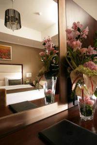 a room with a mirror and a table with flowers at Ramada Hotel & Suites by Wyndham Ajman in Ajman 