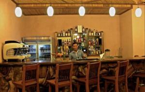 a man standing behind a bar in a restaurant at Corto del Mar Hotel in Coron