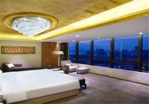 um quarto com uma cama grande e uma janela grande em Xiamen Airlines Lakeside Hotel em Xiamen