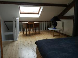 a bedroom with a bed and a desk and a window at Loft Zola in Dijon +4 photos