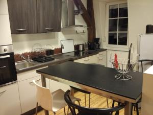 a kitchen with a black table and white appliances at Loft Zola in Dijon